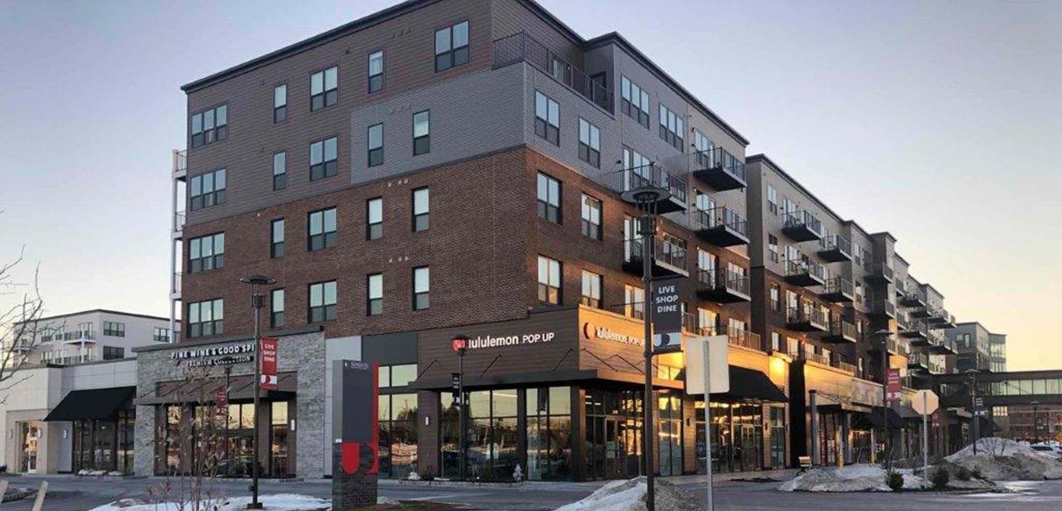 An angled view of the Promenade at Upper Dublin showcasing the east side of the building and storefronts on the first floor.