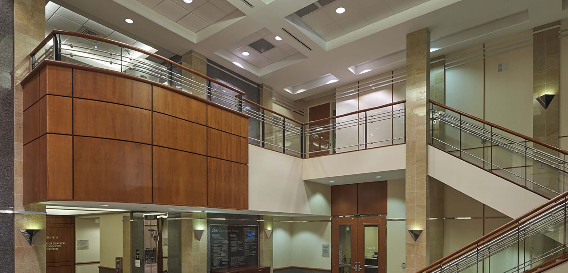 An interior view of the Rothman Brinton Lakes building showcasing the second floor balcony and staircase leading down to the first floor.