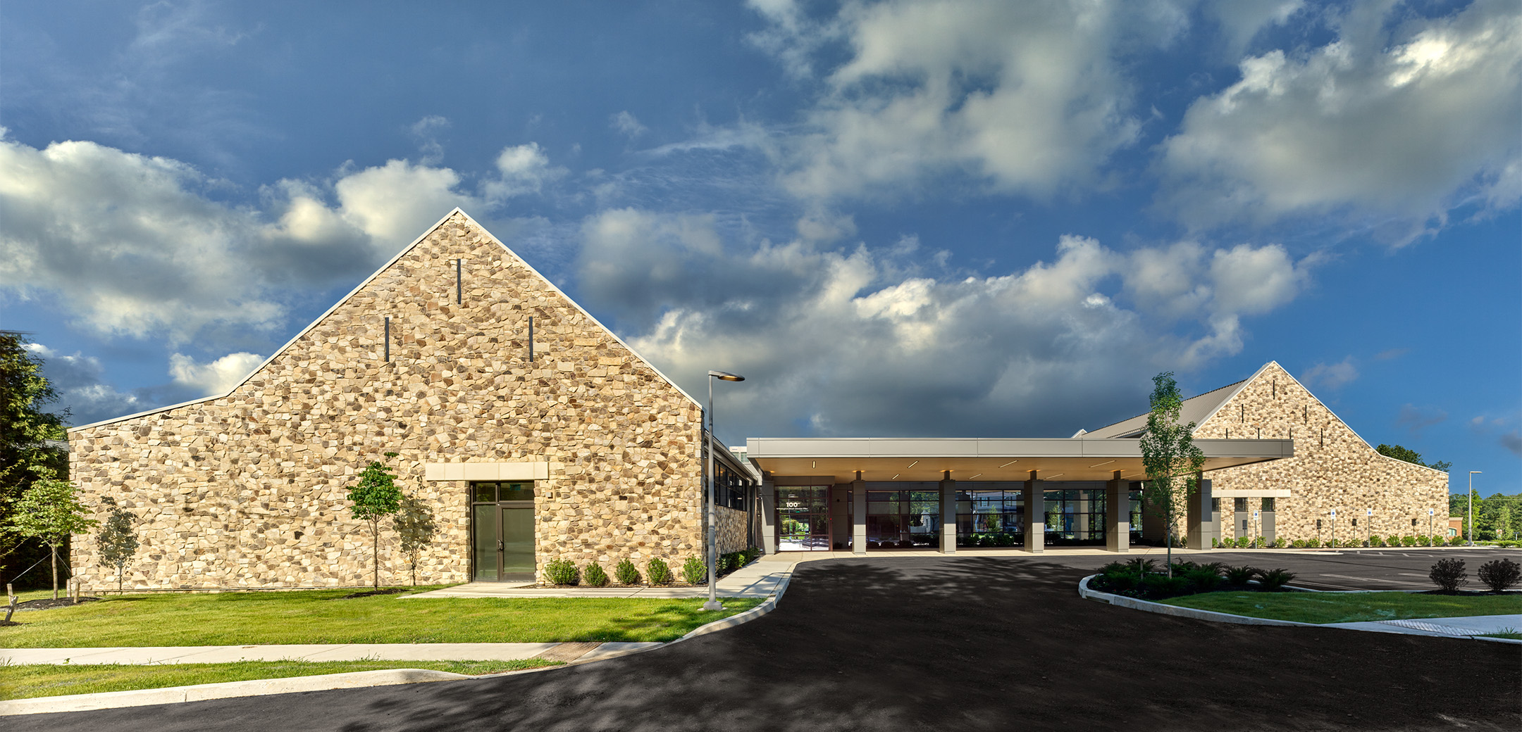 A front view of the Astoria Health building, showcasing the main entrance and front parking lot.