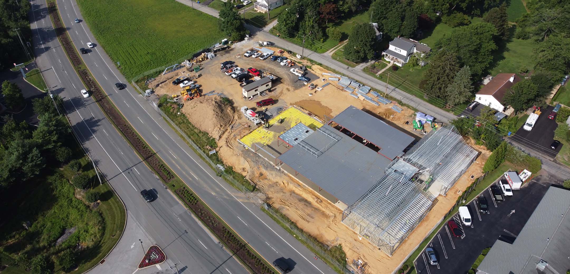 A drone aerial image of the Astoria Health building showcasing the site during the construction process, building layout and street area.
