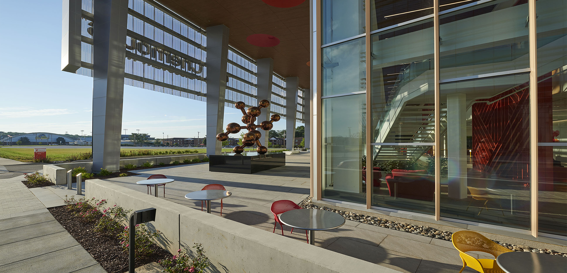 Daytime photo of the exterior front patio of the Chemours Discovery Hub with small tables and chairs.