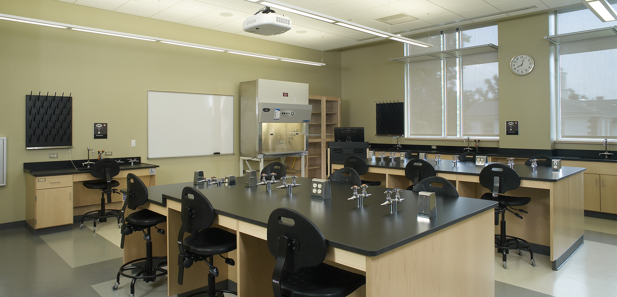 An interior view of the Delaware Valley College science lab, showcasing the large workbenches with built in faucets and a fume hood in the background.