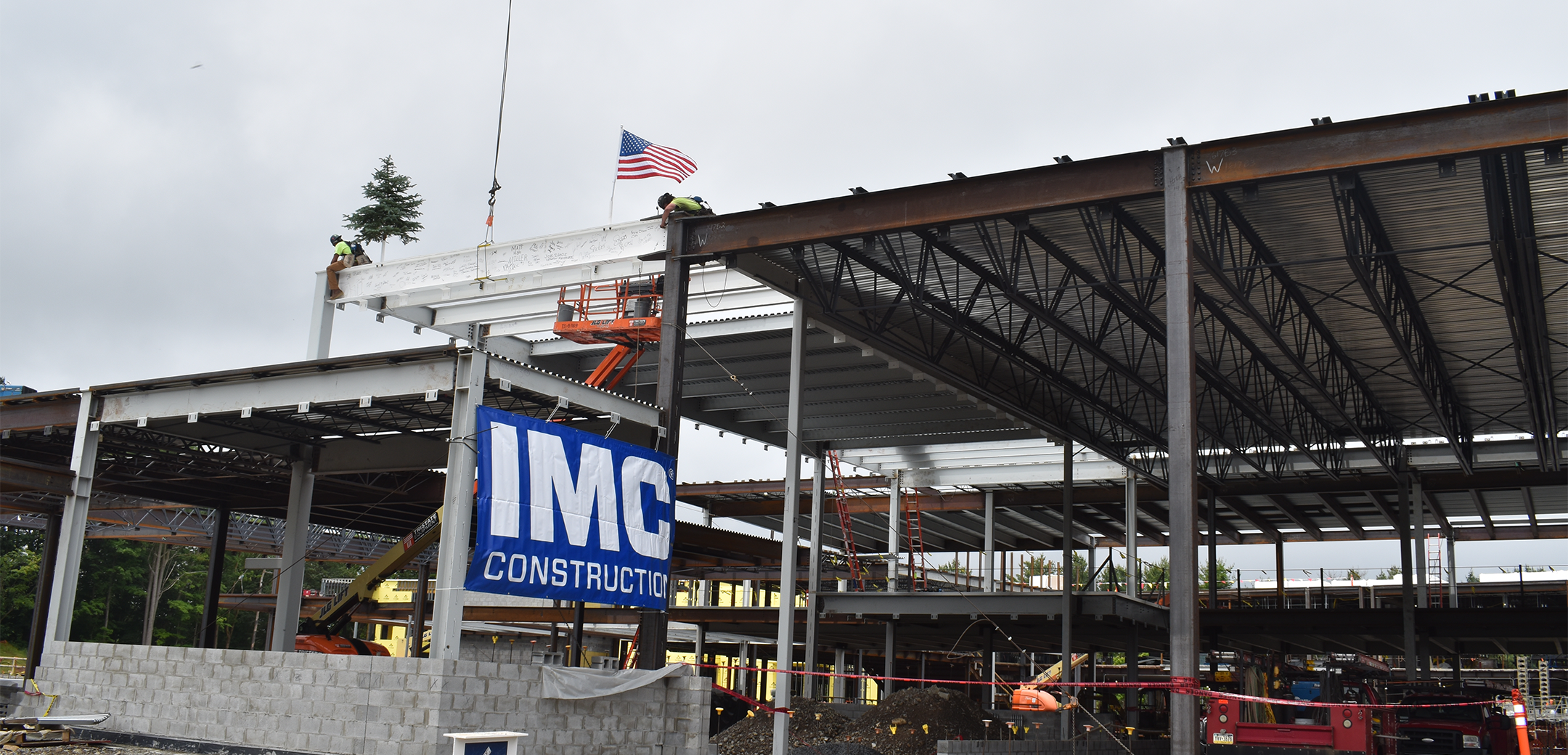 A close up photo of the Lower Merion Middle School building concrete frame featuring an IMC sign hanging on the side.