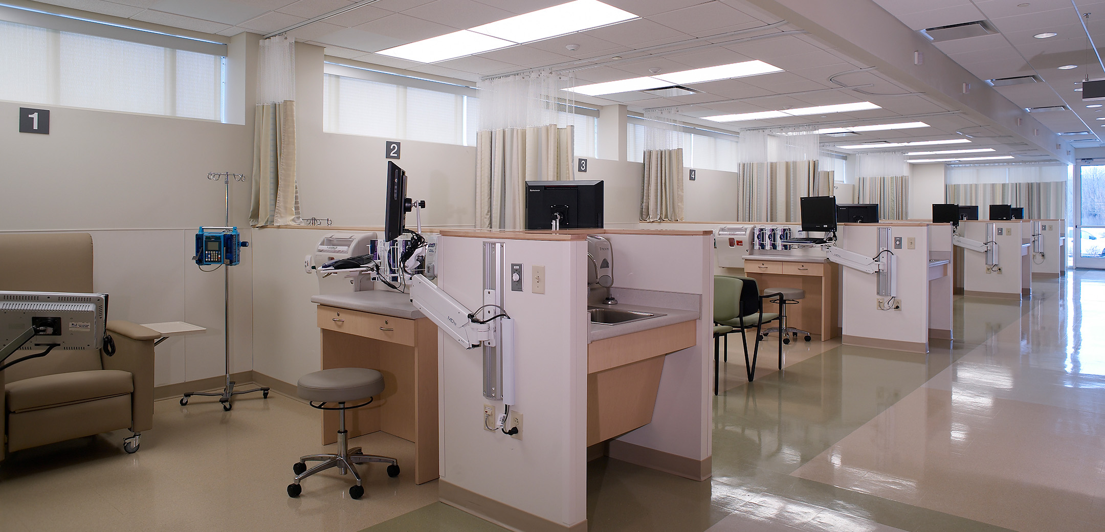 An interior view of the Abramson Cancer Center showcasing the individual patient examination cubicles with extendable monitors and accessible faucets.