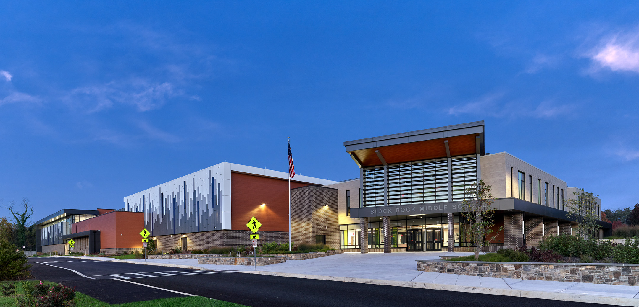 The front of Black Rock Middle School featuring a large brick building and wood facade