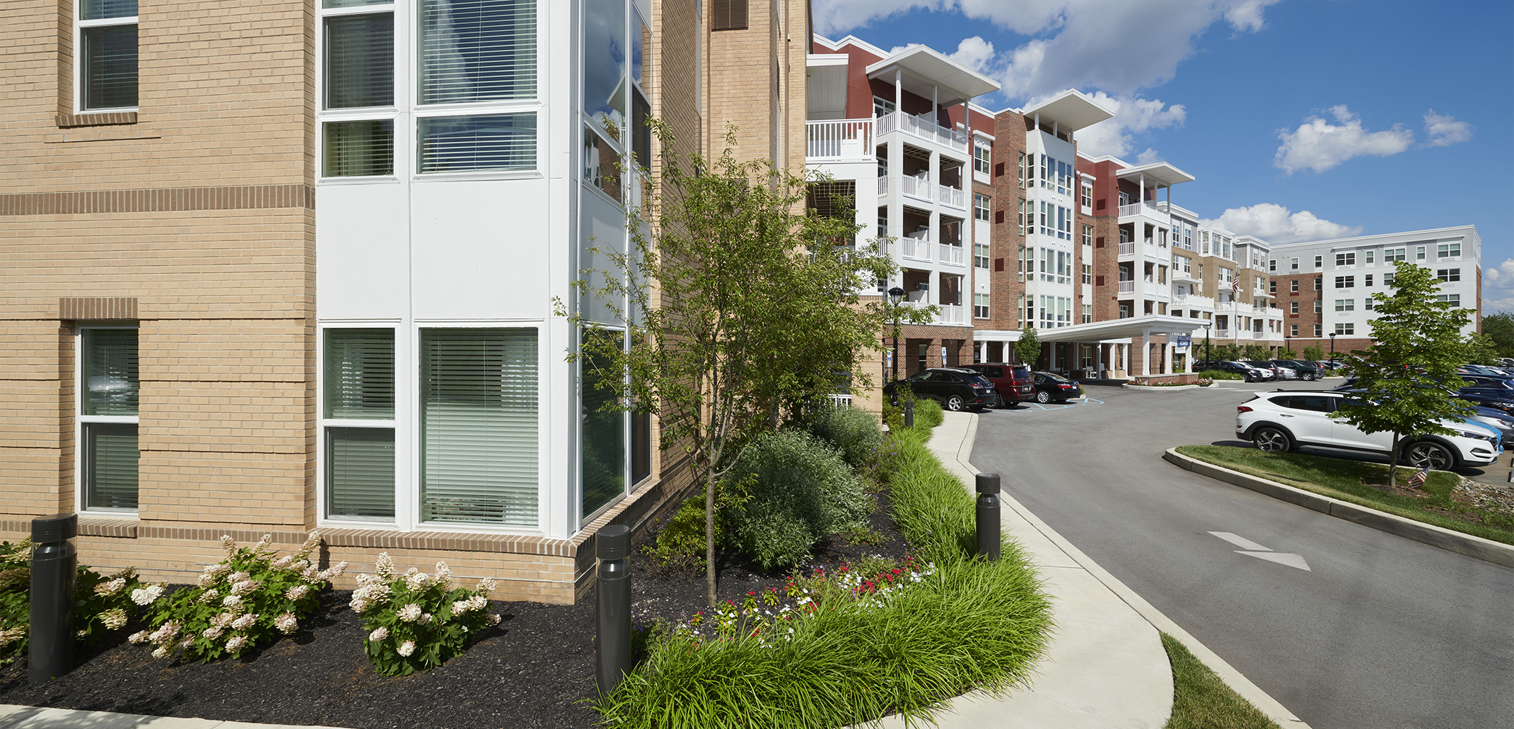 A close up exterior view of the Brightview Devon building showcasing the length of the building and corner design with a sidewalk wrapping around it.