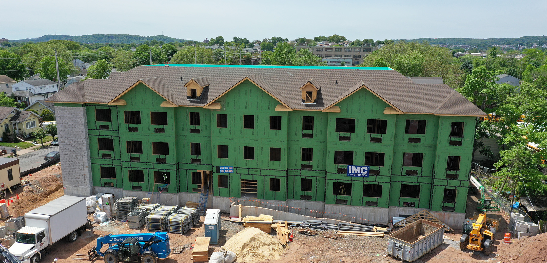 A front view of Chelsea Senior Living facility under construction with green exterior walls.