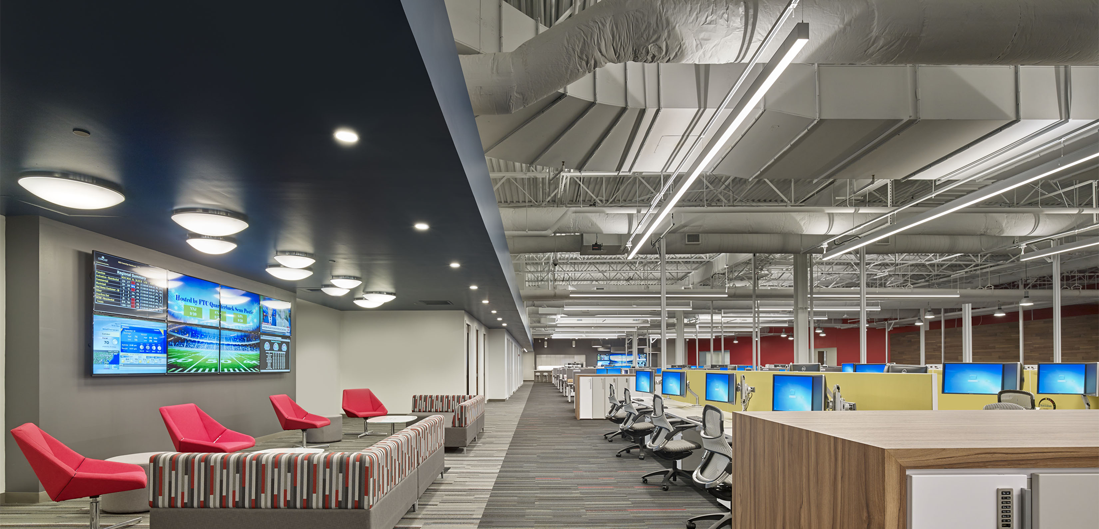 The call center area of the Network Operations center featuring open exposed ceilings with open cubicles on the right and a sitting area with tvs on the left.