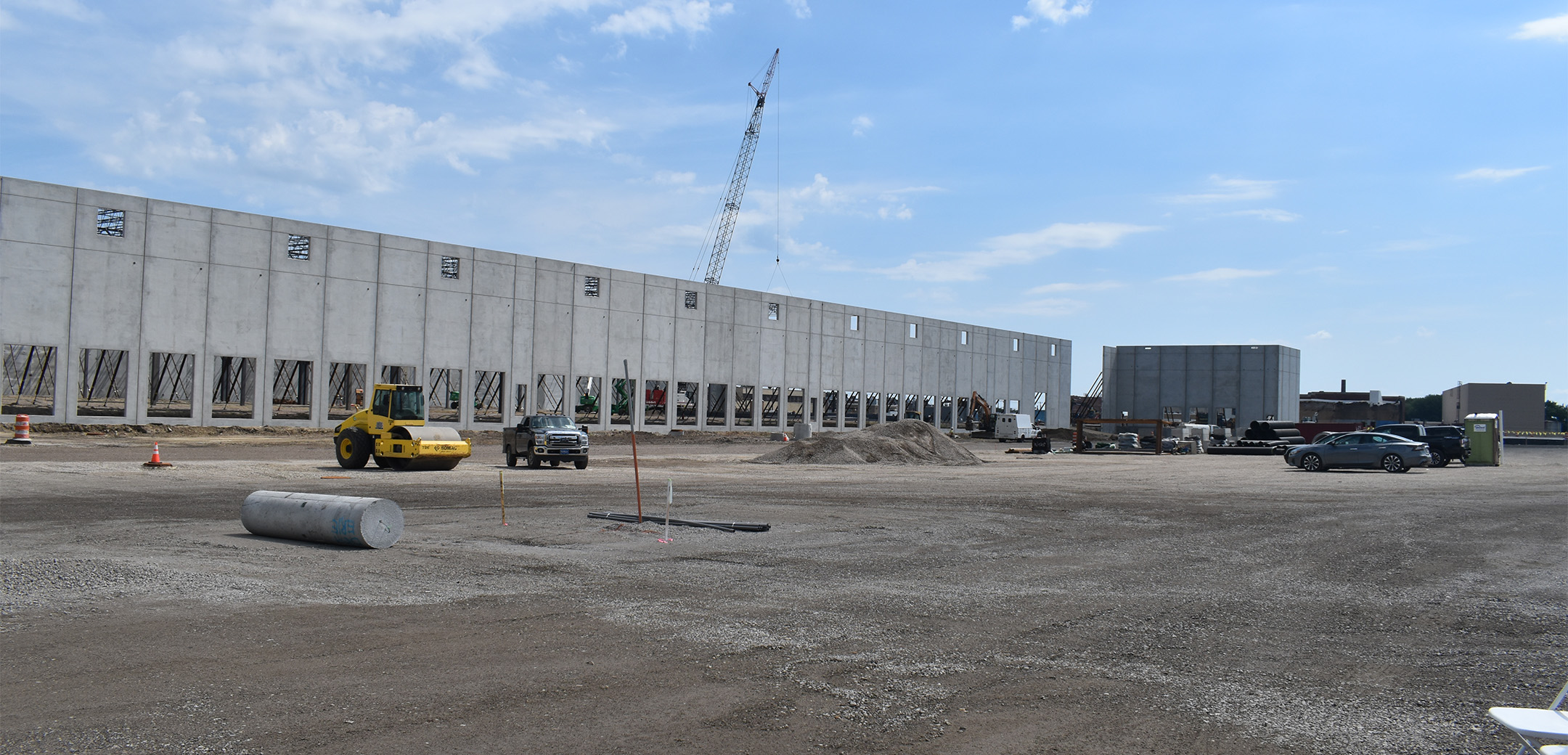 A groundview of part of the Crown 95 Logistics Center under construction with gray wall panels on a dirt covered project site
