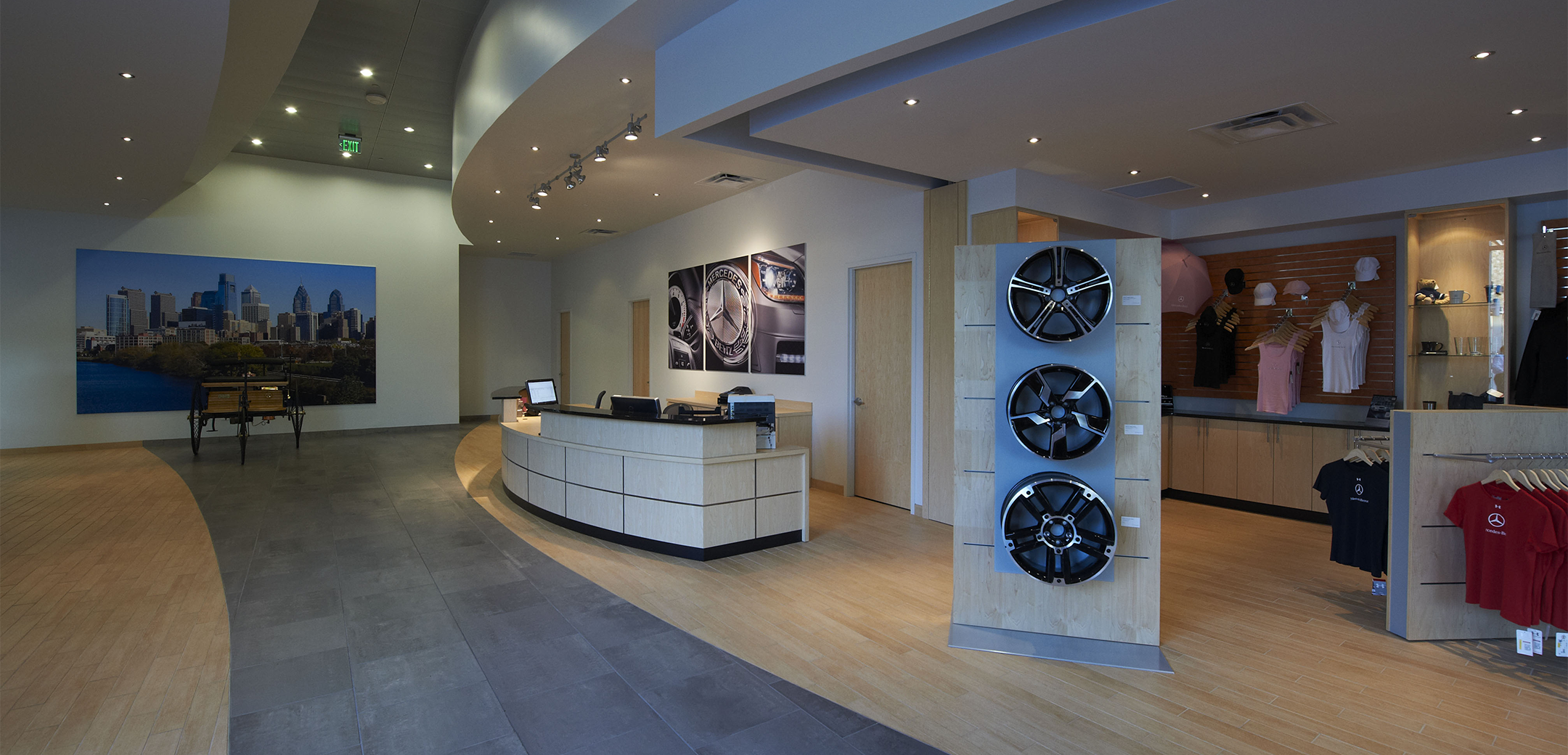 An interior view of the Euro Motorcars lobby reception desk, seating and cityscape photo in the background and gift shop on the right side.