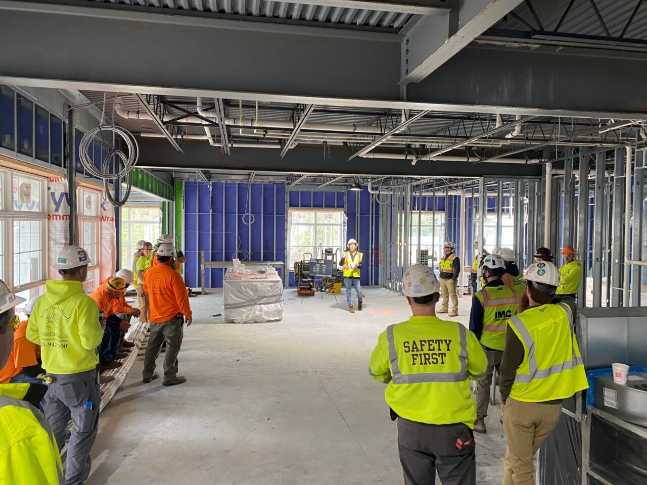 A group of construction workers watching a safety presentation on an IMC project site