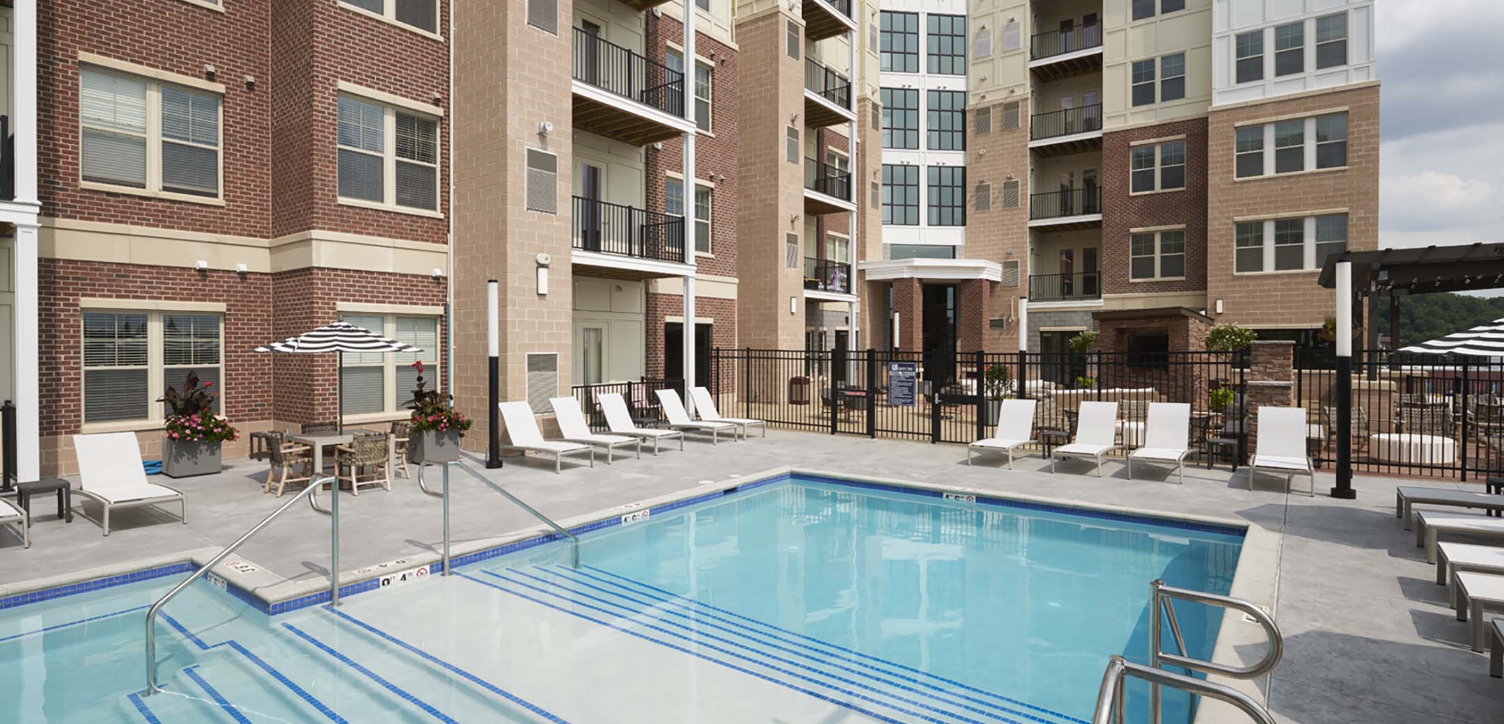 A close up view of the Granite Run Apartment buildings inner courtyard with an outside multi-level pool with seating around it.