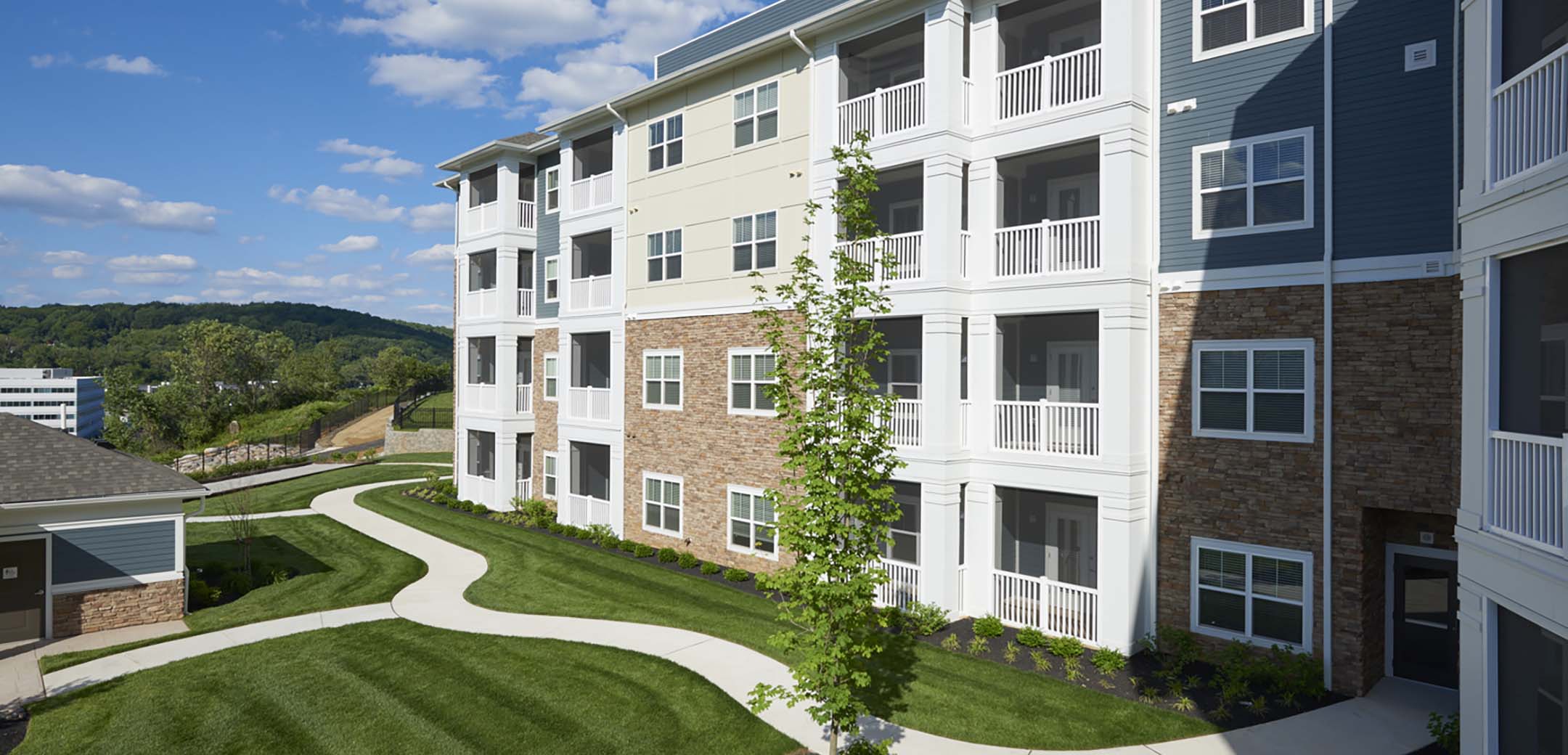 An angled view of the Haven building back courtyard showcasing the apartment balconies and paved grass pathways.