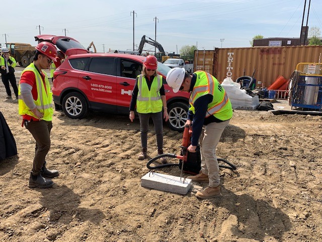 A construction worker giving a training on a jackhammer