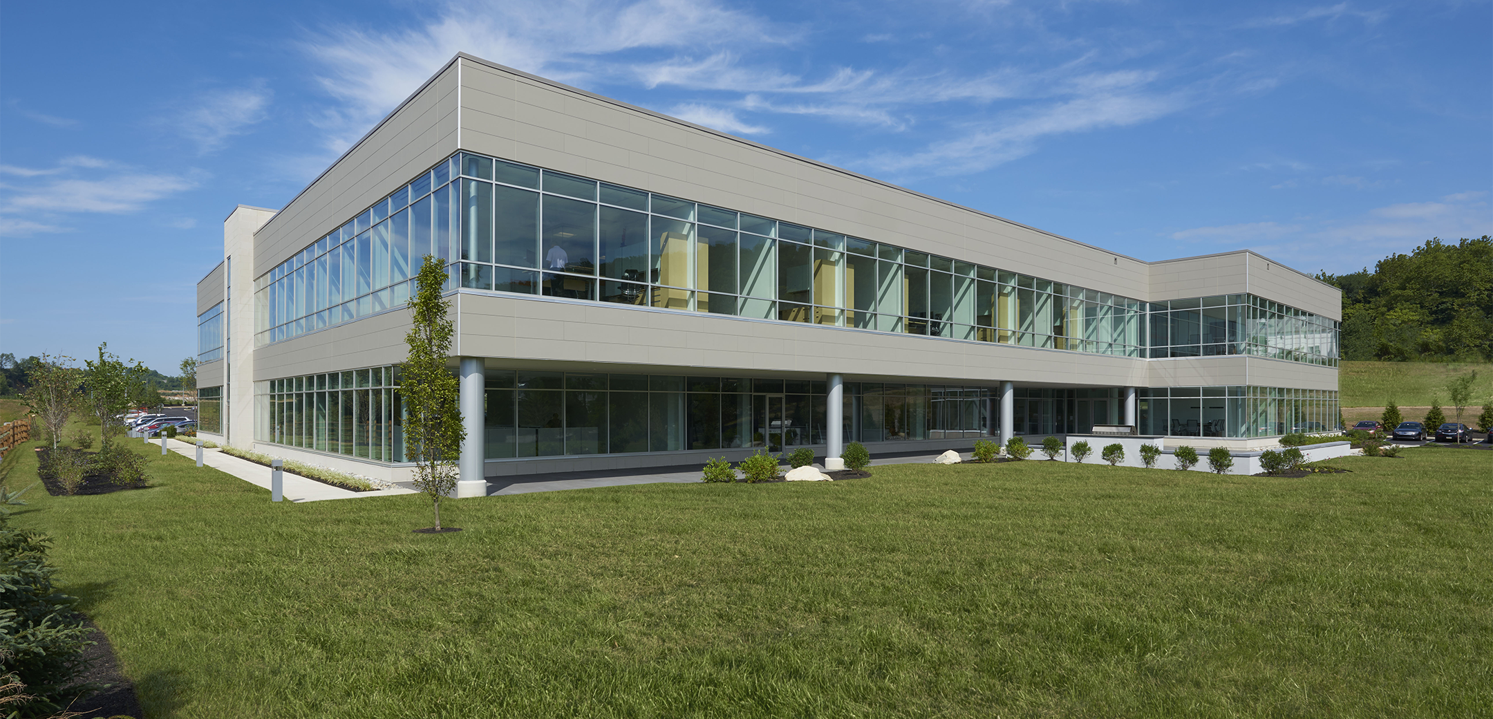 An angled back view of he IFM Erector building showcasing an overhang second floor with height sized windows.