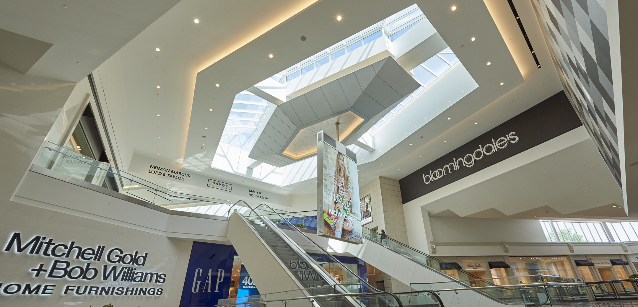 An interior view of the KOP Expansion building's escalators showcasing the angular modern design and skylights on the ceiling.