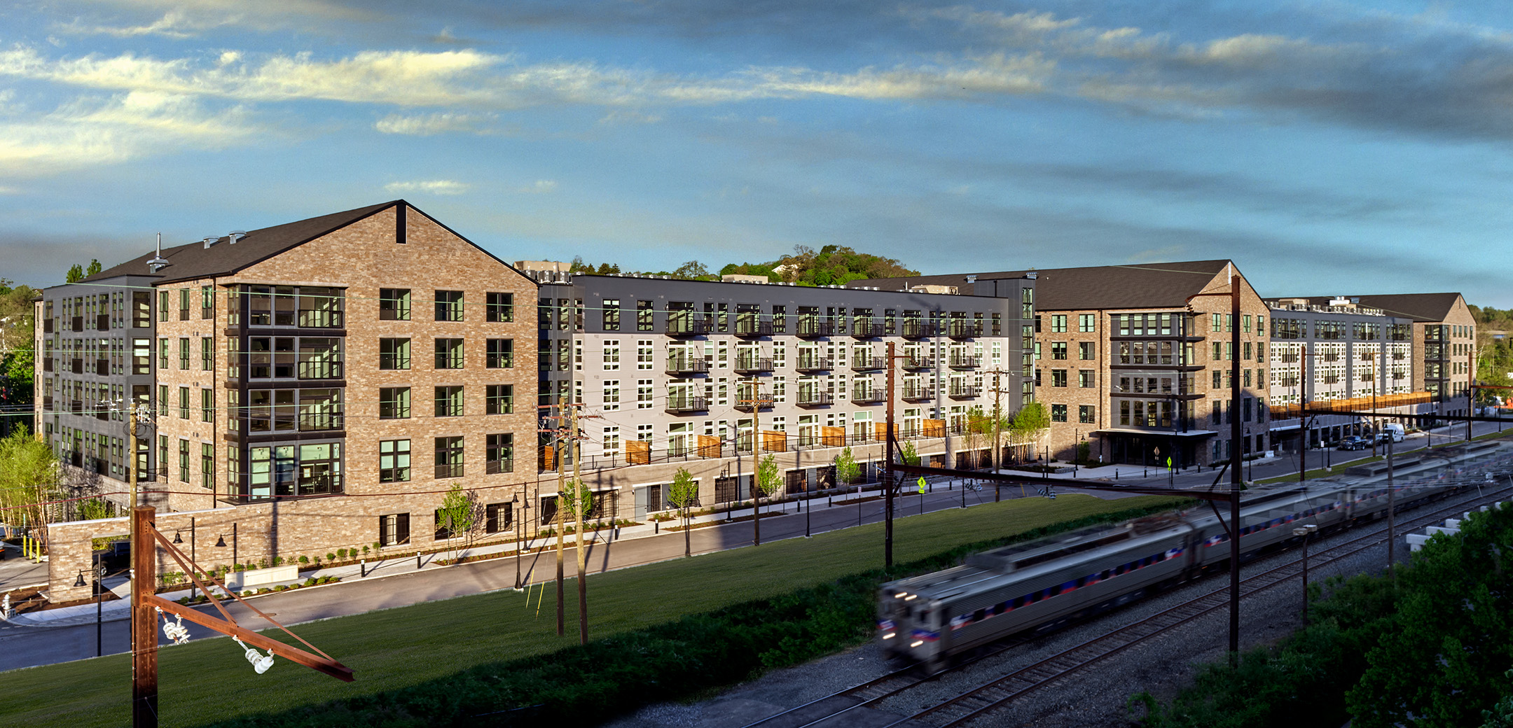 An angled view of the Matson Mill apartment building featuring brick exterior facade and the SEPTA in front.