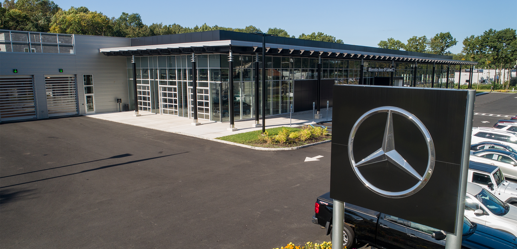 The exterior view of the Mercedes Benz of Caldwell back side garage with shutter doors, and glass shutters that lead into the main showcase floor.