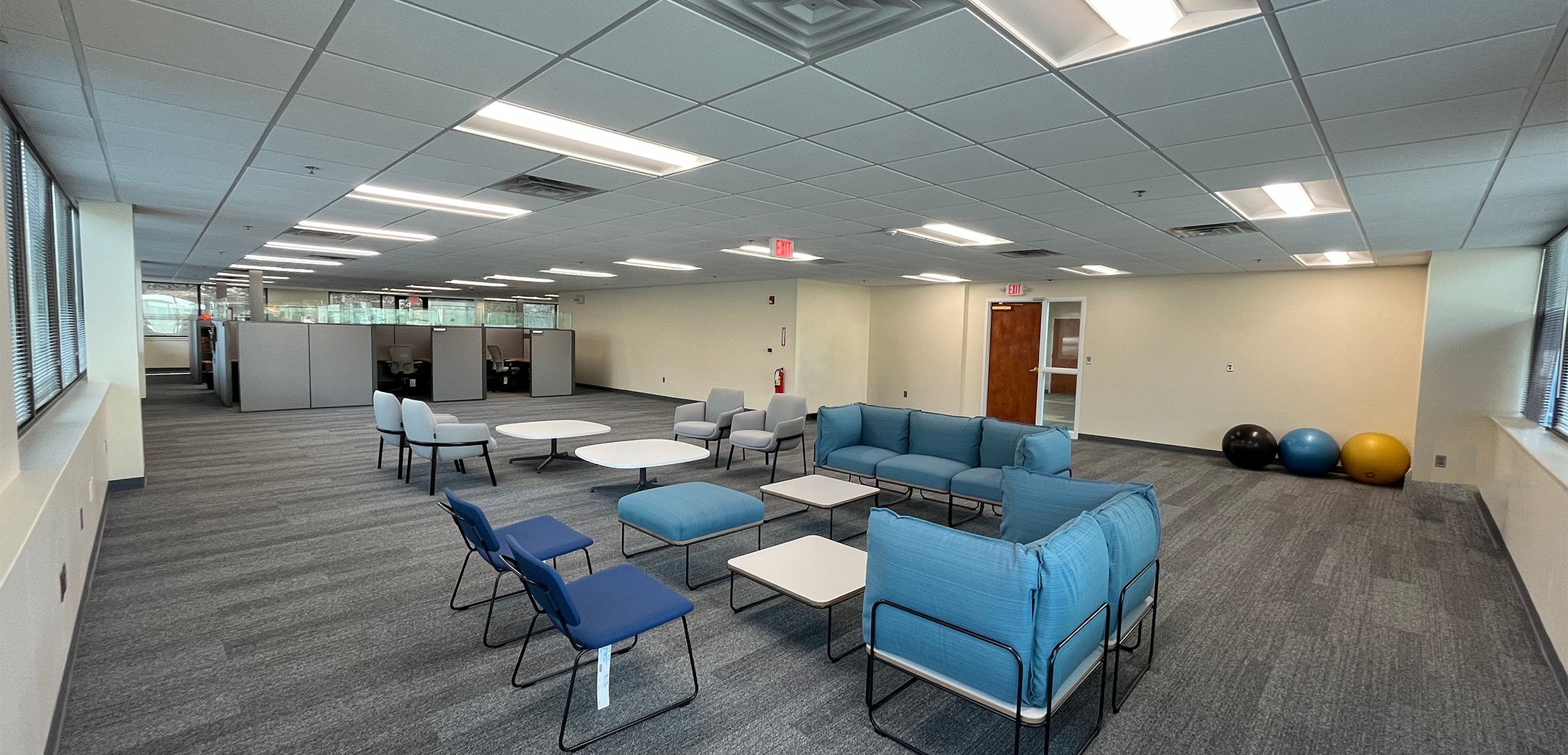 An angled interior view of the PA Leadership Charter School showcasing the rest seating area with couches and chairs and private cubicles in the background.