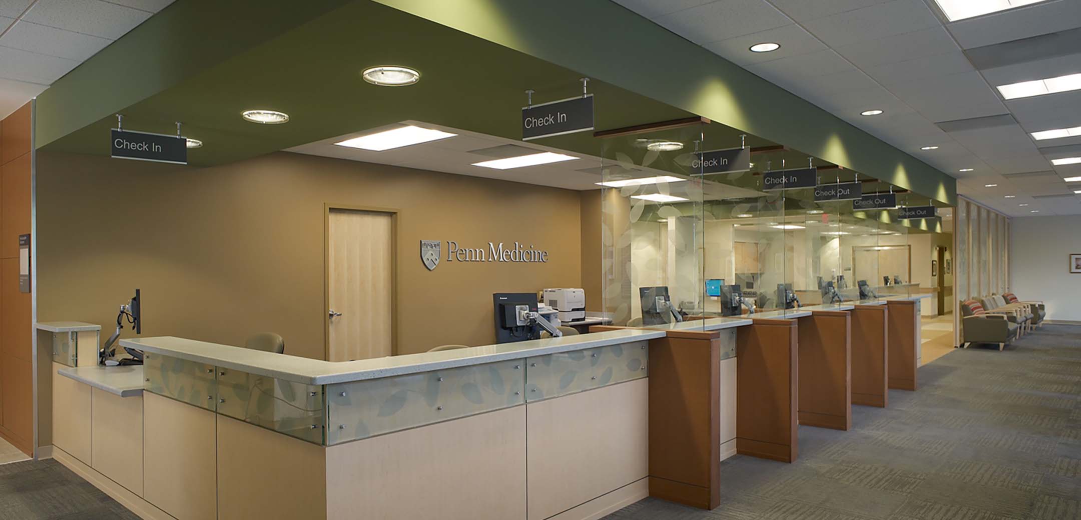 An interior view of the Pen Med VF, showcasing the multiple check in desks with orange glass dividers.