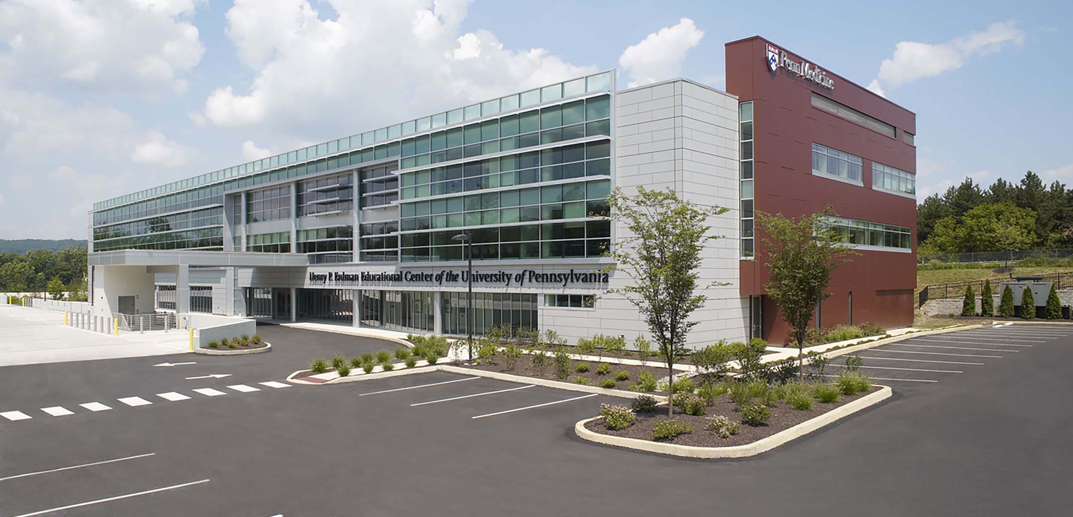 The exterior of the Pen Medicine VF building showcasing the precast panel, full length glass window front design and main parking lot.