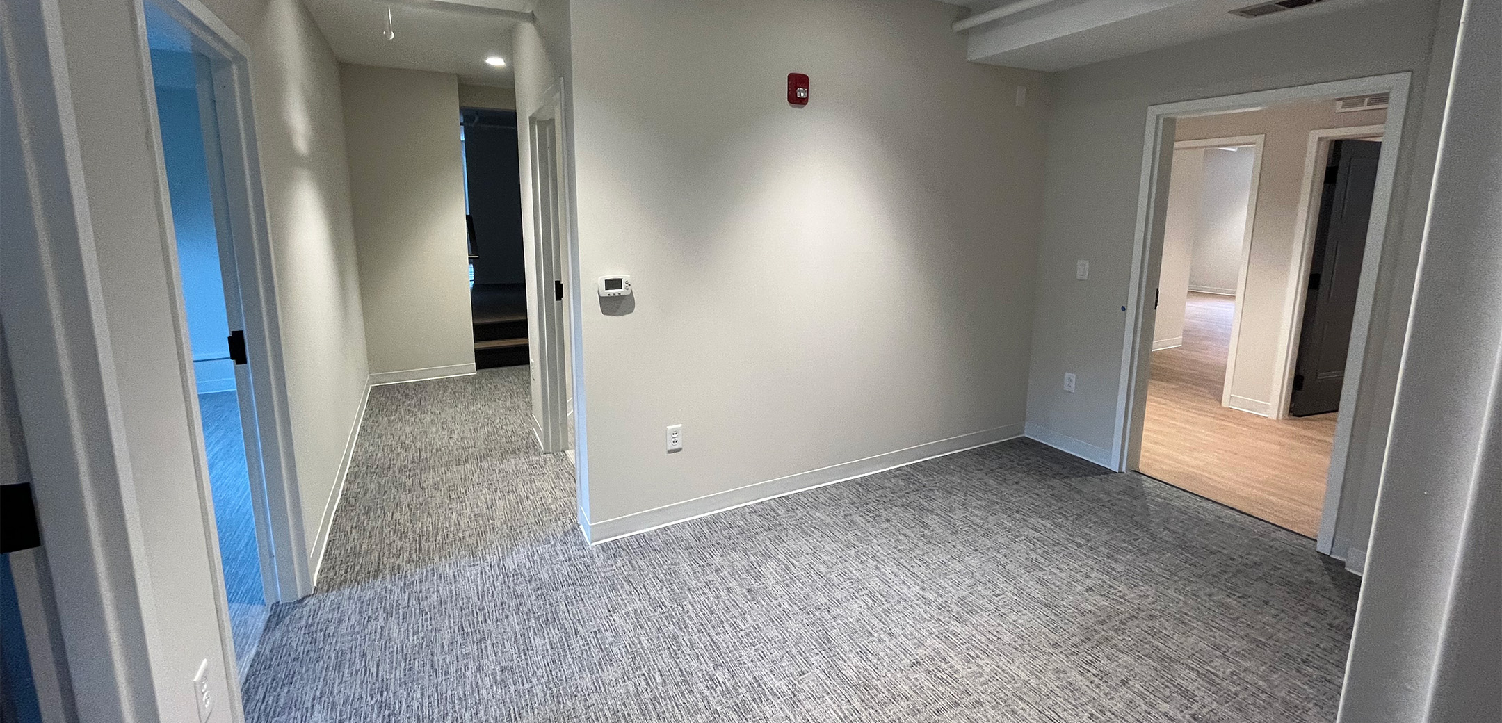 An empty room of Philadelphia Integrative Psychiatry with gray carpets and white walls.