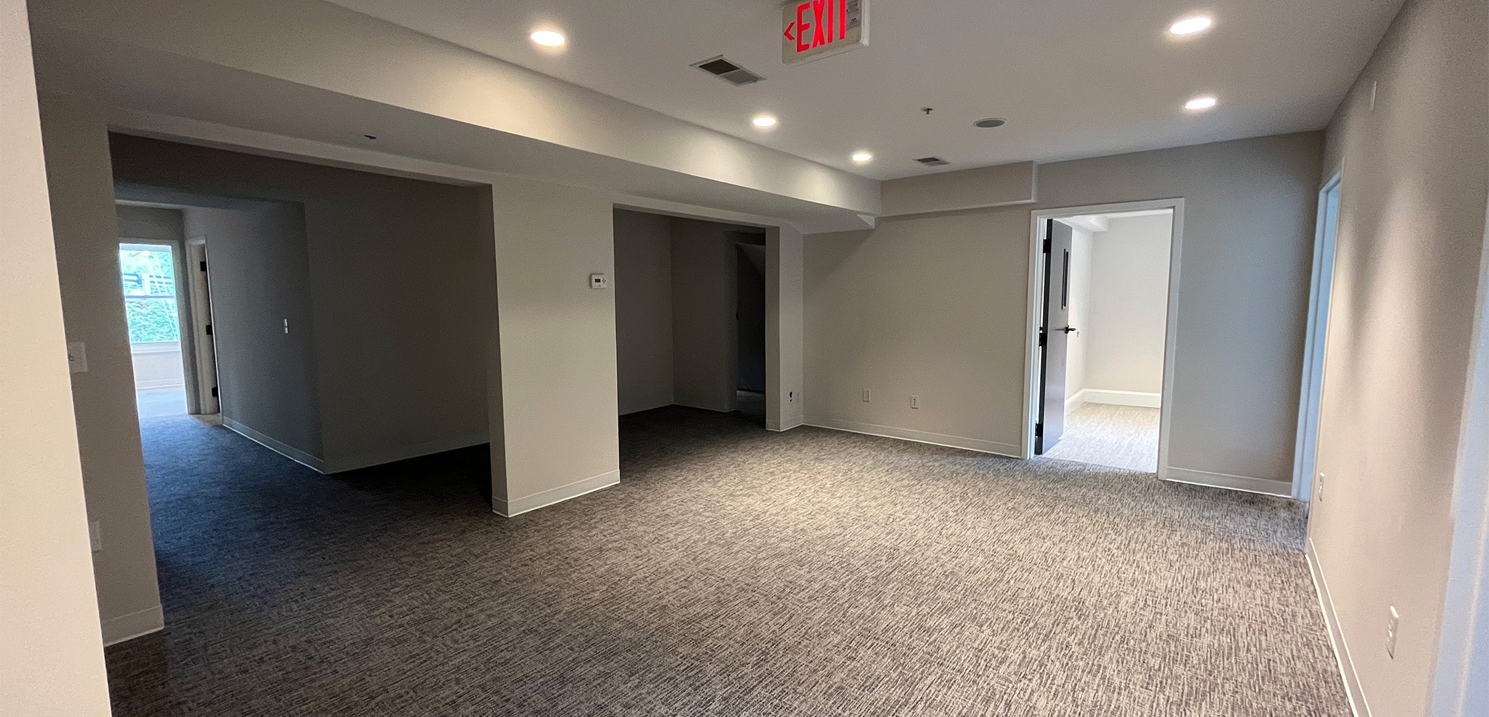 An empty room of Philadelphia Integrative Psychiatry with gray carpets and white walls.