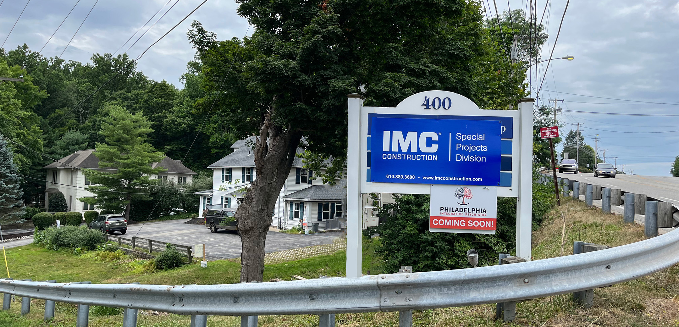 A blue sign that says ``IMC Construction Special Projects Division`` on the corner of the Philadelphia Integrative Psychiatry Office