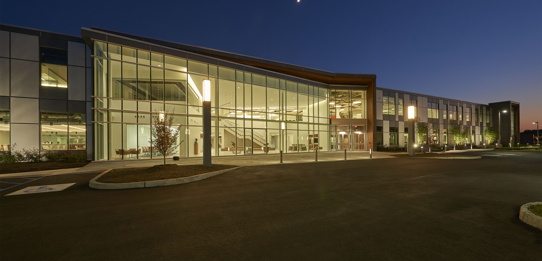 A nighttime exterior photo of Sunoco headquarters showcasing the interior light illuminating the front parking lot.