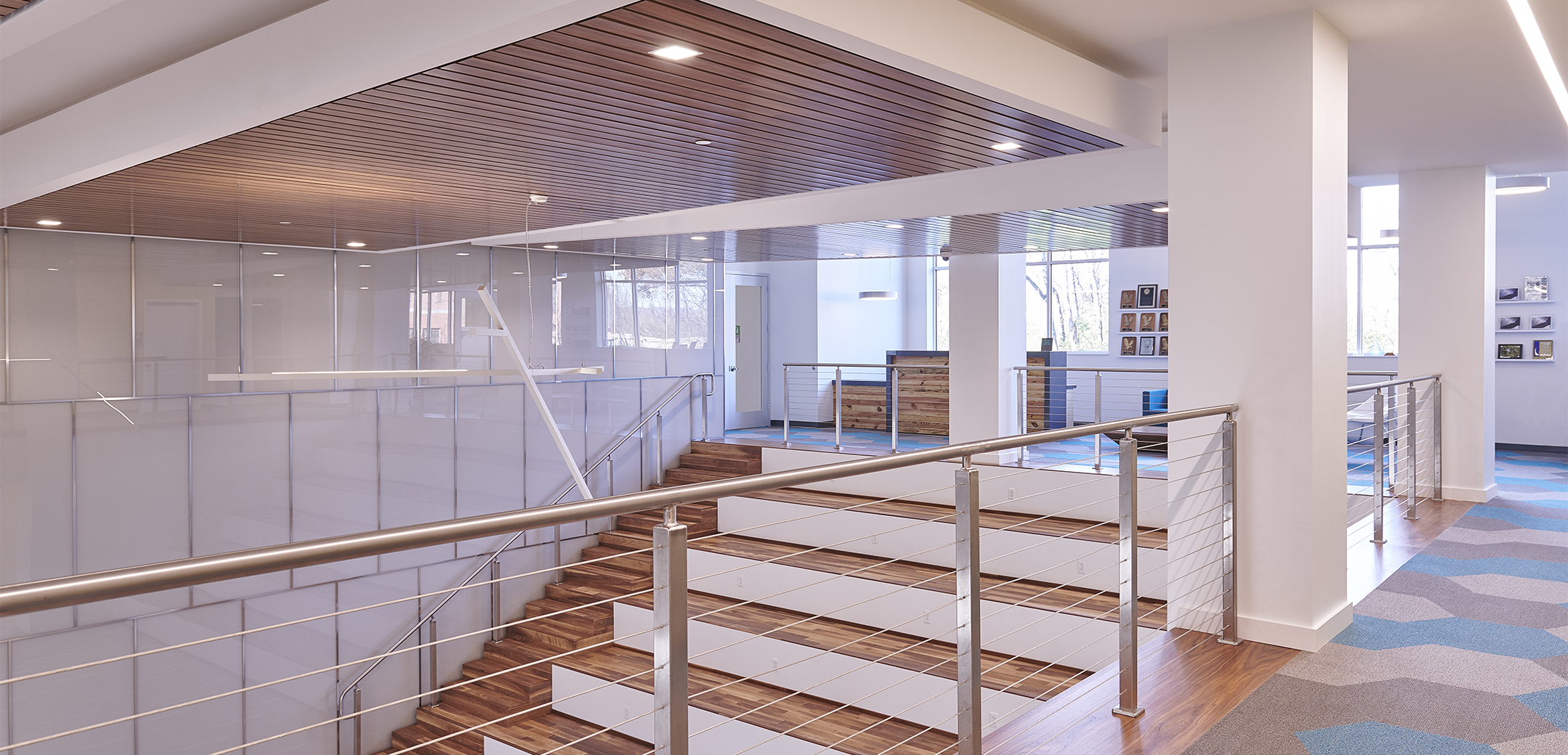 The interior space of UGI Energy Services featuring a staircase with wooden grandstand style seating connecting the lobby to the second floor.