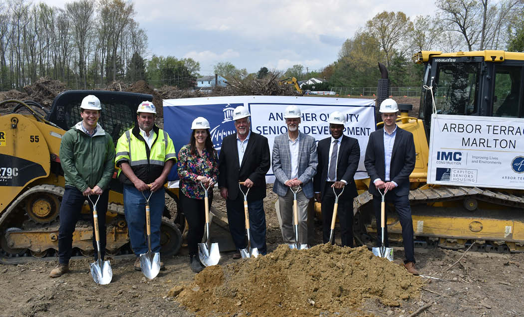 IMC Employees with hardhats and shovels in front of large construction equipment for Capitol Seniors Housing Marlton