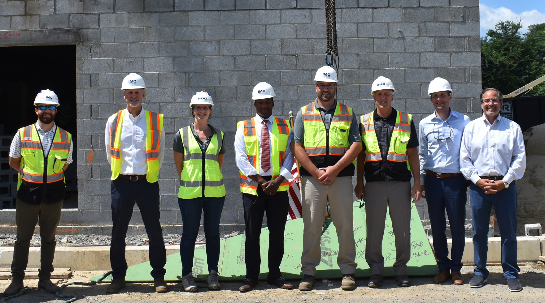 A group of IMC employees posing for a photo on the construction site of Matson Mill.