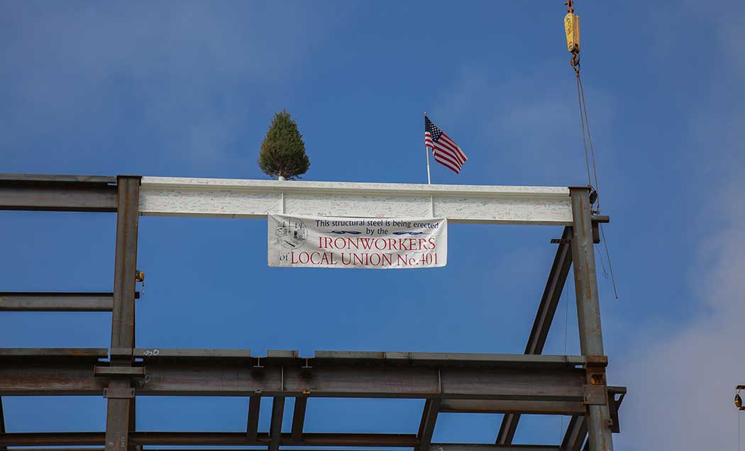 A white iron beam with an American flag and a sign for the Ironworkers Local Union