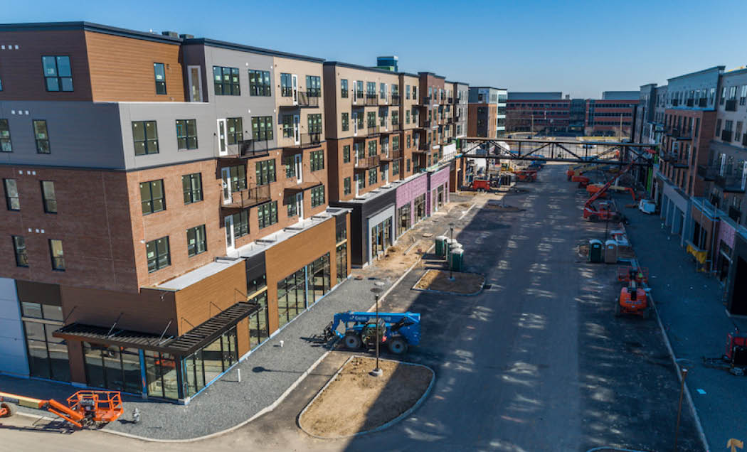Progress photo of construction of multi-family, mixed-use development with equipment