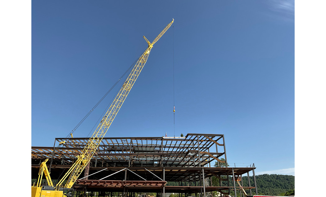 Large yellow crane lifting beam into place at Good Shepherd rehabilitation hospital