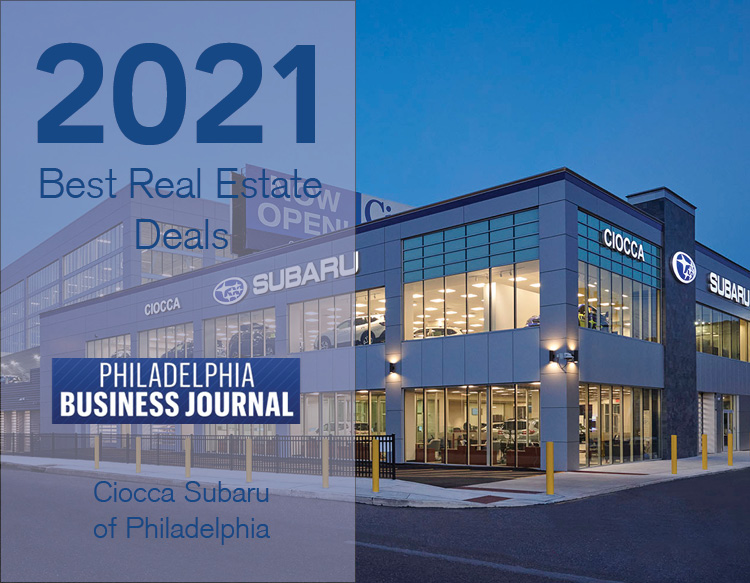 An awards graphic featuring the 2021 Best Real Estate Deals, PBJ logo placed on a half white tinted image of Ciocca Subaru of Philadelphia.