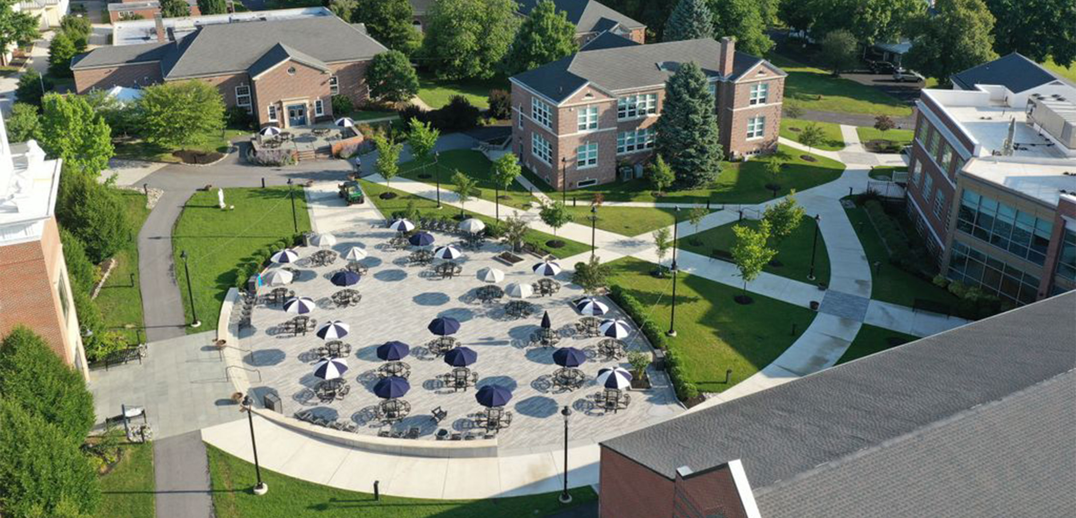 An aerial view of Malvern Preparatory School`s Campus showcasing the courtyard with tables and chairs surrounding by brick buildings