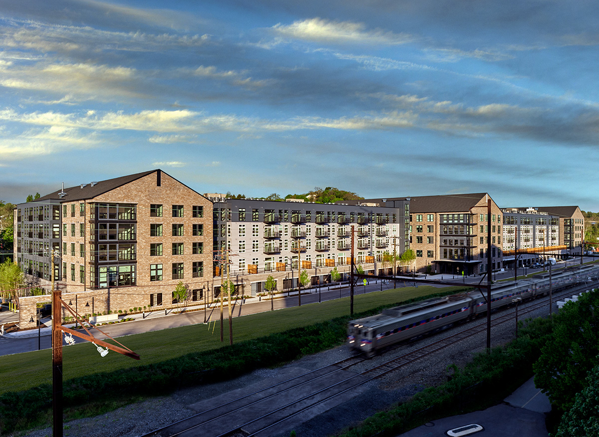 An angled view of the Matson Mill apartment building featuring brick exterior facade and the SEPTA in front.