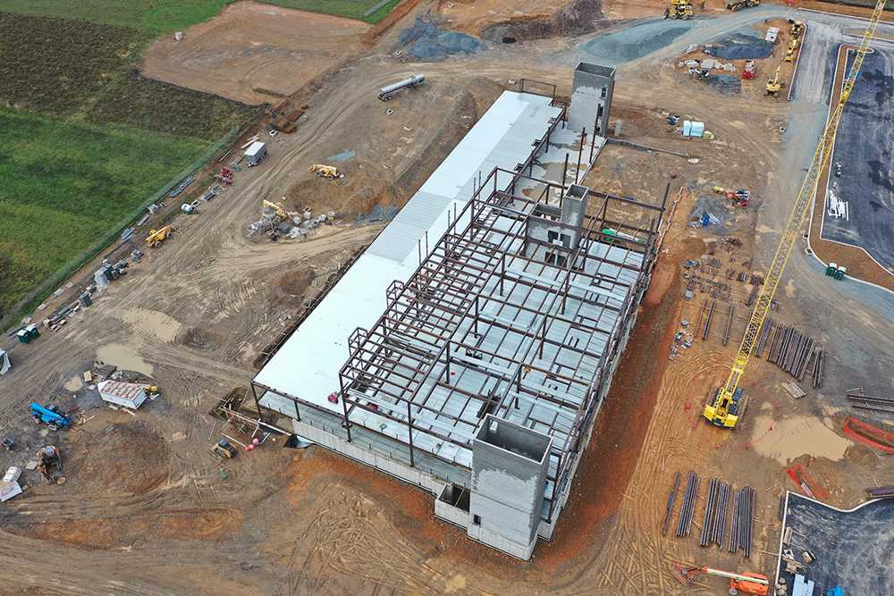 An aerial view of the construction site of St. Luke's Carbon County Hospital featuring a large building of steel