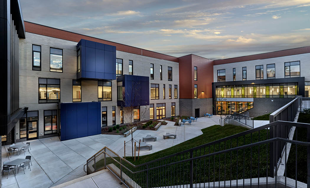 The exterior backside of Black Rock Middle School featuring a terrace enclosed within the building walls.