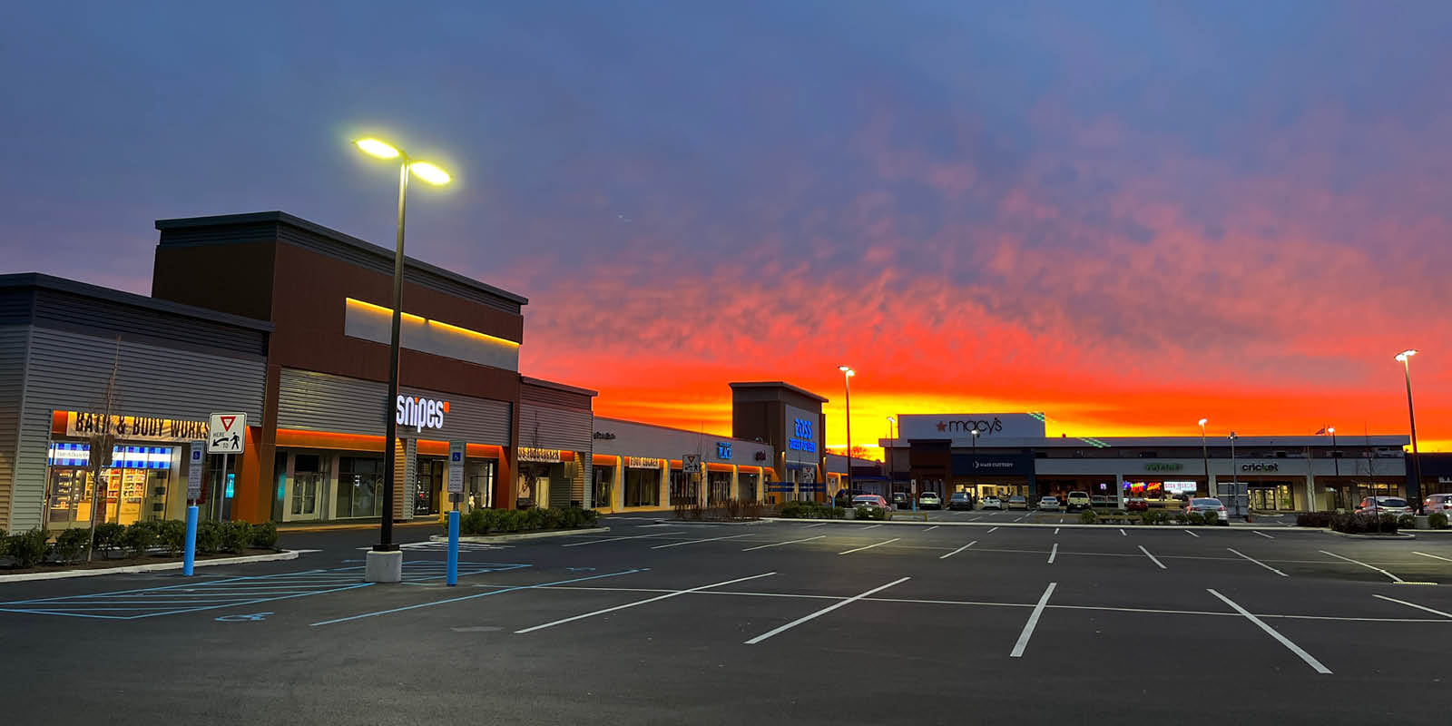 Exterior facade of strip mall with sunrise behind buildings