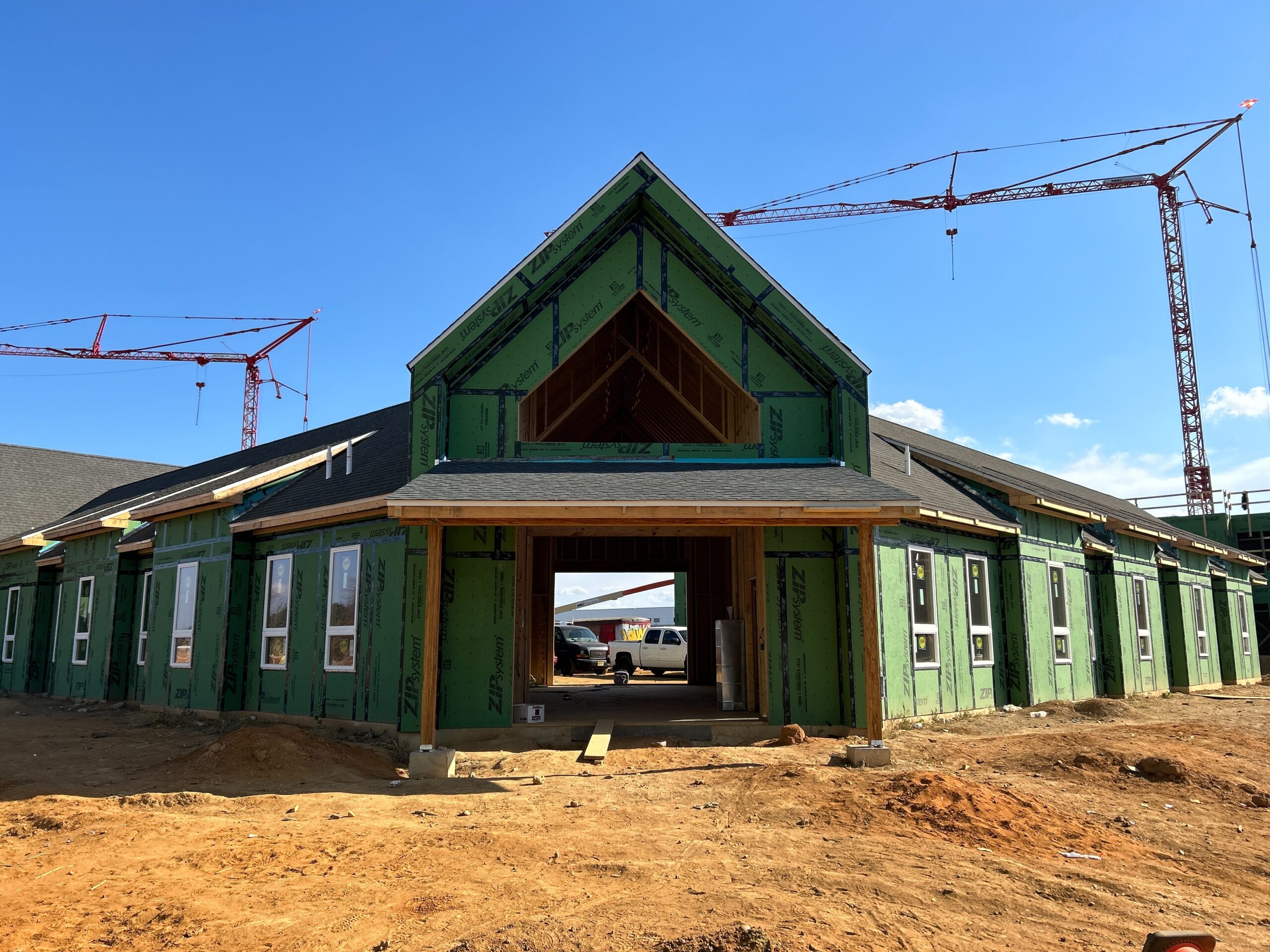 Green building with crane in the background.