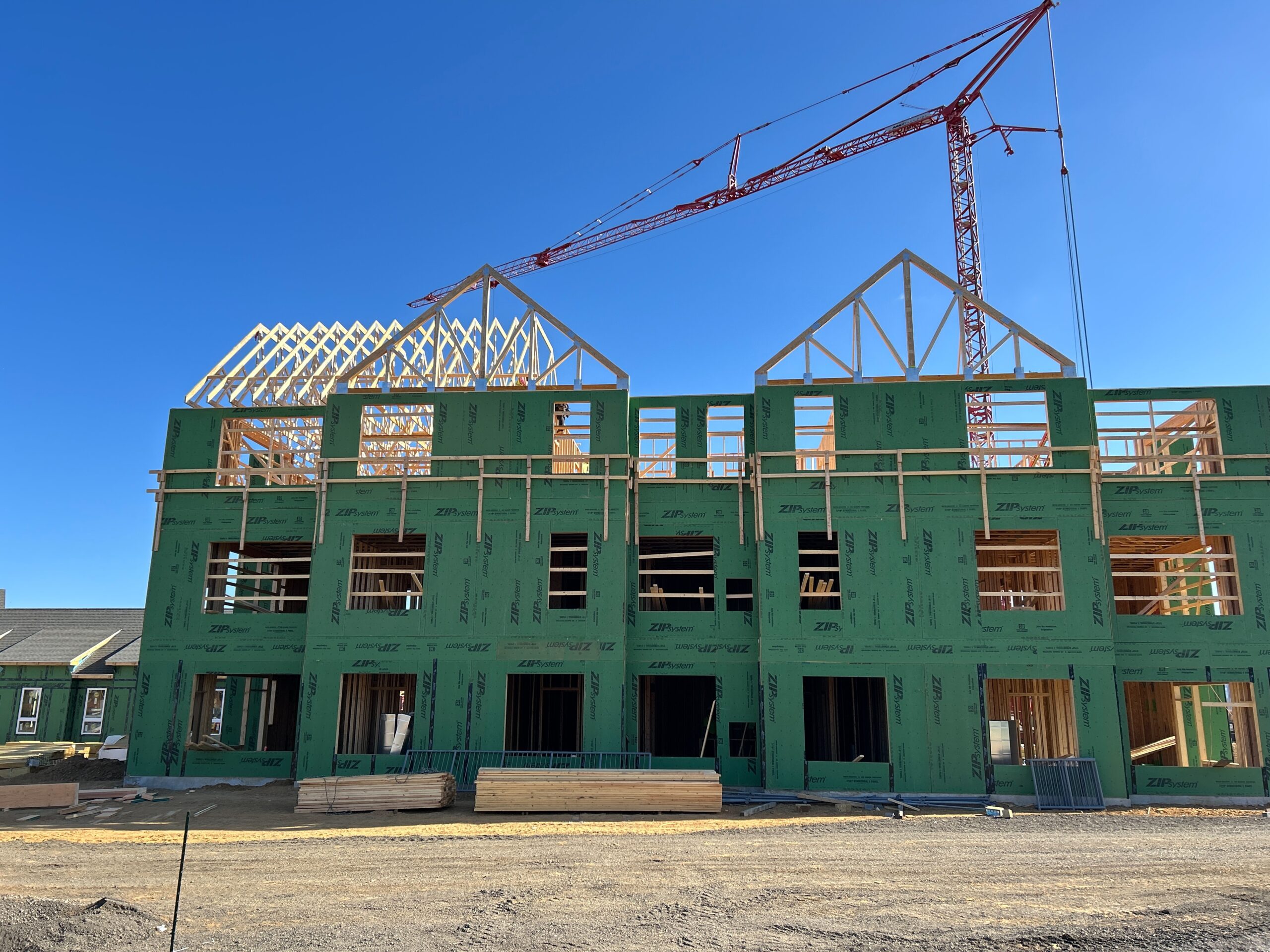 Green building with red crane in the background